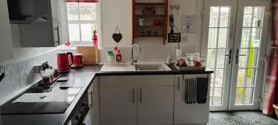 a kitchen with white cabinets and a sink at The Stables in Tregaron