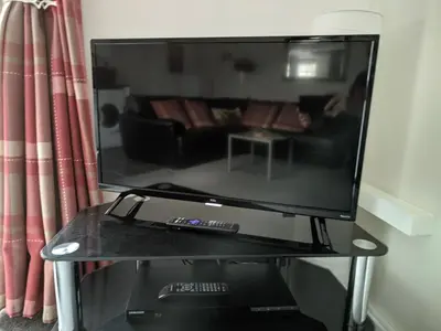 a large flat screen tv on a table with a couch at The Stables in Tregaron