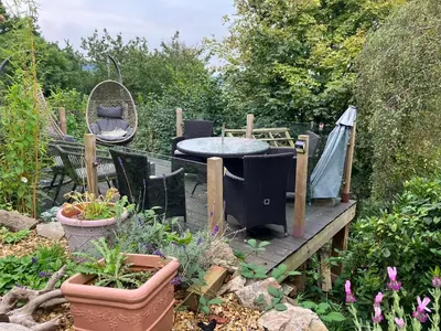 a garden with a table and chairs and plants at Kennet House in Ludlow