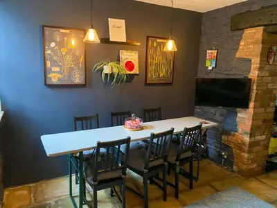 a dining room with a table and chairs and a tv at Kennet House in Ludlow