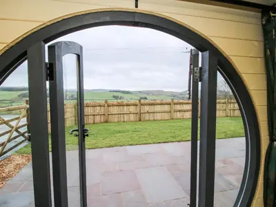 an arched door to a patio with a fence at Callow Pod in Shrewsbury