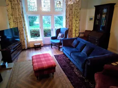a living room with a blue couch and a large window at Tranquil getaway near Brecon Beacons in Llandovery