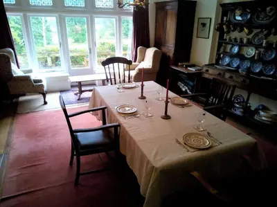 a dining room with a table with plates and wine glasses at Tranquil getaway near Brecon Beacons in Llandovery