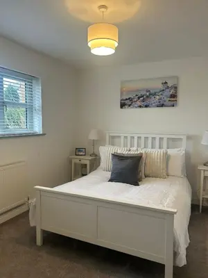 a bedroom with a white bed with a pillow on it at BROOK HOUSE 4a in Llangollen