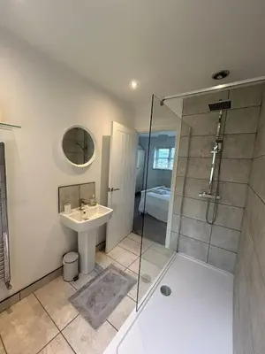 a bathroom with a sink and a glass shower at BROOK HOUSE 4a in Llangollen