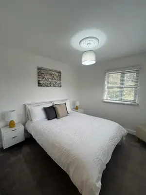 a bedroom with a large bed with white sheets at BROOK HOUSE 4a in Llangollen
