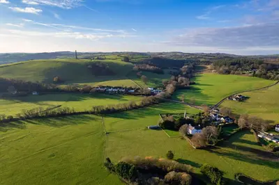 an aerial view of a green field with houses at Ty Bledrws - family retreat near the Cardigan Bay coast in Llangybi
