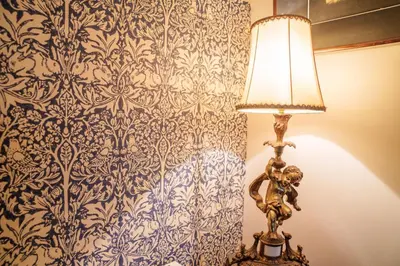 a lamp in a room with a blue and white wallpaper at Ty Bledrws - family retreat near the Cardigan Bay coast in Llangybi