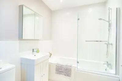 a white bathroom with a sink and a shower at Ty Bledrws - family retreat near the Cardigan Bay coast in Llangybi