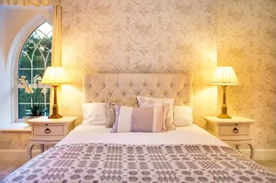 a bedroom with a large bed with two lamps at Ty Bledrws - family retreat near the Cardigan Bay coast in Llangybi
