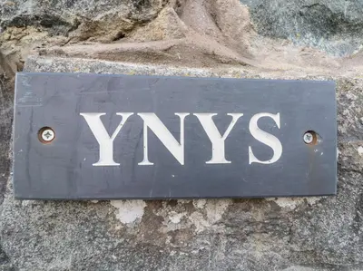a sign that says yxs on a stone wall at Ynys in Dyffryn