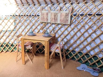 a small table and chairs in a yurt at 'Villager' the Yurt at Pentref Luxury Camping in Penuwch