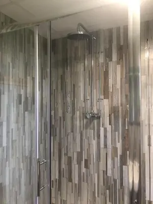 a shower in a bathroom with a shower curtain at 'Villager' the Yurt at Pentref Luxury Camping in Penuwch