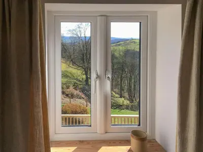 a window with a view of a green field at Tan Y Llidiart in Llangedwyn