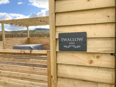 a sign on the side of a wooden building at Swallow Lodge - Uk42540 in Winforton