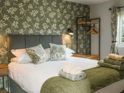 a bedroom with a large white bed with a green wall at Swallow Lodge - Uk42540 in Winforton