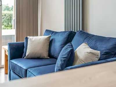 a blue couch with three pillows on it at Cuckoo Lodge - Uk42541 in Winforton