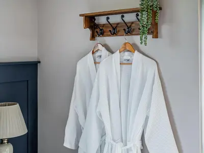 a row of white jackets hanging on a rack at Cuckoo Lodge - Uk42541 in Winforton