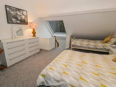 a bedroom with a bed and a dresser at Bronwen House in Llanbedr