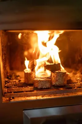 a fire in an oven with bread in it at Pine Tree House with Hot tub & Sauna in Barmouth
