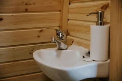 a bathroom with a sink and a roll of toilet paper at River Side Cabin with Hot tub Snowdonia in Barmouth