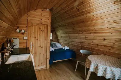a bedroom with a bed in a wooden cabin at Snowdonia Mawddach Cabin and hot tub Glamping in Barmouth