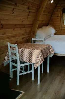 a room with a table and two chairs and a bed at Willow Cabin & Hot Tub in Barmouth