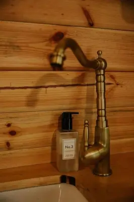 a bathroom sink with a faucet and a bottle of soap at Willow Cabin & Hot Tub in Barmouth