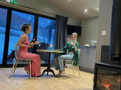 two women sitting at a table in a room at Quirky, Luxury Hideaway in Llanbrynmair