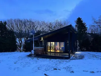 a small house in a snow covered field at Quirky, Luxury Hideaway in Llanbrynmair