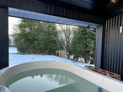 a bath tub in a house with a window at Quirky, Luxury Hideaway in Llanbrynmair