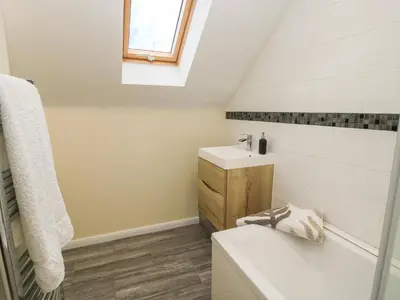 a white bathroom with a sink and a toilet at Stable Cottage in Bishops Castle