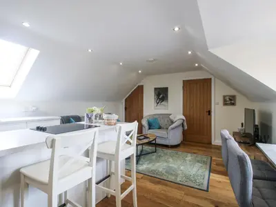 a kitchen and living room with a table and chairs at Stable Cottage in Bishops Castle