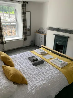 a bedroom with a large bed with towels on it at The Slaters Arms Corris in Machynlleth