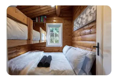 a bedroom with two bunk beds in a log cabin at Snowdonia Escapes # TRANQUIL CABIN with Views, Wi-Fi, Dog Friendly & Parking in Trawsfynydd