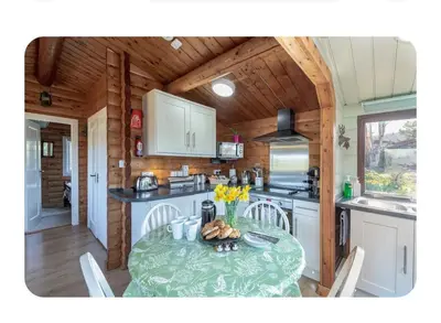 a kitchen with a table in a tiny house at Snowdonia Escapes # TRANQUIL CABIN with Views, Wi-Fi, Dog Friendly & Parking in Trawsfynydd