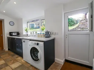 a kitchen with a washing machine and a sink at Ael Y Bryn in Blaenau-Ffestiniog
