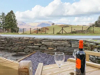 a bottle of wine sitting on a table with a glass at Ael Y Bryn in Blaenau-Ffestiniog