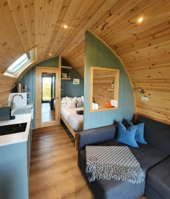 a living room with a couch and a bed at Odli Glamping - Aderyn in Welshpool