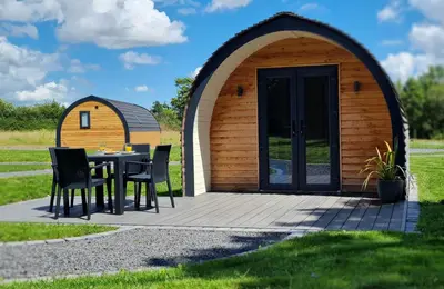 a gazebo with a table and chairs on a patio at Eastridge Glamping Pods in Shrewsbury