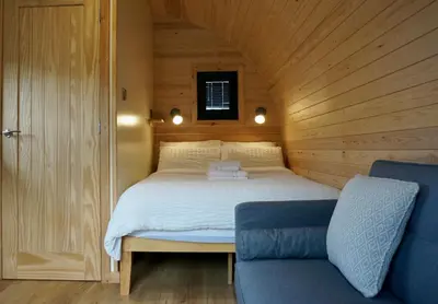 a bedroom with a bed in a wooden room at Eastridge Glamping Pods in Shrewsbury