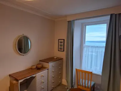 a bedroom with a dresser and a window at Arvonia sleeps 7, sea views, dog friendly in New Quay