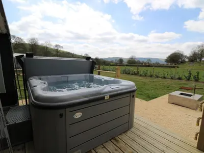 a hot tub sitting on top of a deck at Heron in Nantmel