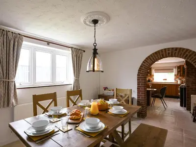 a kitchen and dining room with a wooden table at Dolwen Isaf in Llangadfan