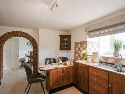 a kitchen with a sink and a chair in a room at Dolwen Isaf in Llangadfan