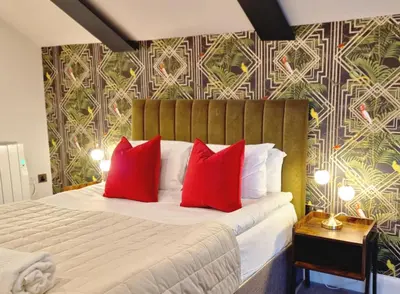 a bedroom with a large bed with red pillows at The Academy House by Bevolve in Shrewsbury