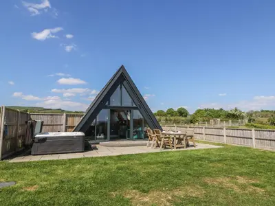 a glass house with a grill and a table at Elan Valley Welsh - The Sheepfold in Llandrindod Wells