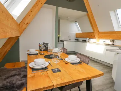 a kitchen and dining room with a wooden table and chairs at Elan Valley Welsh - The Sheepfold in Llandrindod Wells