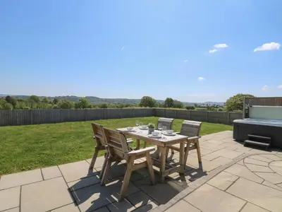 a patio with a table and chairs and a grill at Elan Valley Welsh - The Sheepfold in Llandrindod Wells