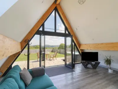 a living room with a blue couch and a large window at Kerry Hill - The Sheepfold in Llandrindod Wells